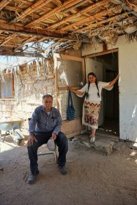 Luz María Villa Poblano, detrás de su esposo, en la puerta de su vivienda en la Misión Santa Gertrudis, en una zona incomunicada del estado de Baja California Sur, en el noroeste de México. A sus 71 años, ella encabeza una batalla por el reconocimiento del pueblo indígena cochimí y de su lengua. Crédito: Daniela Pastrana/IPS
