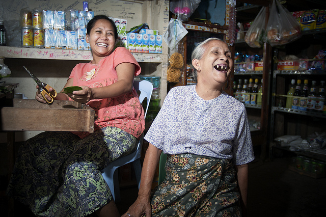 Una mujer de 70 años se ríe junto a su familia en una tienda de alimentos en Tachilek, Myanmar (Birmania). Crédito: Kibae Park/UN Photo.