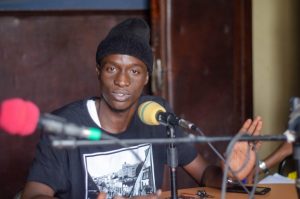 El cantante de hip-hop Matar Judia Ndiaye, llamado Gran Majou Yolof, habla en la Radio Oxy Jeunes Fm, de Senegal, sobre su experiencia tratando de llegar a Europa de forma irregular. Crédito: Cortesía Organización Internacional de las Migraciones (OIM)