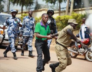 Un policía agarra a la fuerza a un periodista que cubría una manifestación en Kampala, Uganda. Crédito: Cortesía de Wambi Michael.