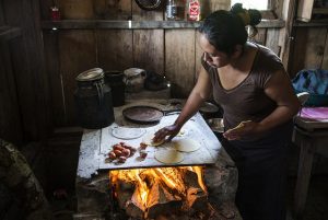 Una mujer elabora tortillas en una cocina a leña, en su precaria vivienda en San Lorenzo, el sureño estado mexicano de Chiapas. En América Latina 8,4 por ciento de las mujeres viven en inseguridad alimentaria severa frente a 6,9 por ciento de los hombres. Crédito: FAO