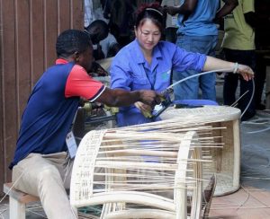 El ghanés Frempong Koranteng (izquierda) aprende a tejer una mesa ratona de bambú y ratán. Crédito: Jamila Akweley Okertchiri/IPS