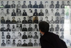 Un turista observa las fotografías de las personas que murieron durante el régimen del Jemer Rojo. Crédito: Robert Carmichael/IPS.