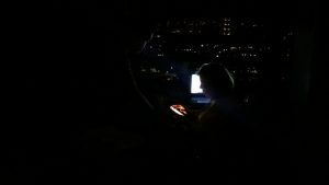 Algunas luces en barrios lejanos, a los que ya había llegado la electricidad, y algo de batería en los dispositivos animan la búsqueda de información sobre los familiares distantes en un hogar de Colinas de Santa Mónica, en una colina de Caracas, durante el inédito apagón de Venezuela. Crédito: Humberto Márquez/IPS