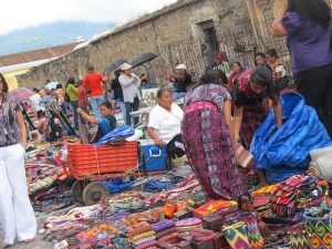 Mujeres indígenas venden artesanías en un mercado en la calle, en la turística ciudad de Antigua, en Guatemala. La venta ambulante es una de las actividades, casi siempre en situación informal, en que deben refugiarse las mujeres en América Latina, ante la persistente falta de empleo decente para ellas. Crédito: Mariela Jara/IPS
