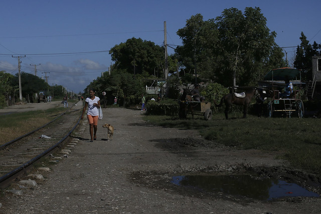 Una mujer camina cerca de las vías de un tren en Palma Soriano, en el este de Cuba, donde el gobierno del municipio, como los de los otros 167 municipios del país, se prepara para asumir las nuevas prerrogativas de autonomía establecidas por la Constitución que el país estrena el 10 de abril. Crédito: Jorge Luis Baños/IPS