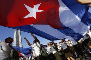 Estudiantes sostienen una bandera de Cuba durante el desfile por el Día Internacional de los Trabajadores, el 1 de mayo, en La Plaza de La Revolución de La Habana. Crédito: Jorge Luis Baños/IPS