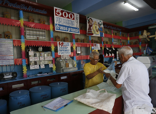 Un cliente recibe arroz en una bodega estatal, que suministra los alimentos a precios subsidiados incluidos en la libreta de racionamiento, cuya eliminación se aleja ante el recrudecimiento de la crisis económica en Cuba. Crédito: Jorge Luis Baños/IPS