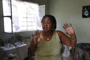 María del Carmen Curbelo, una de las residentes del barrio de La Ciruela, en el municipio de Regla, en La Habana, que sufrió el embate de un gran tornado en enero, cuenta a IPS en la sala de su vivienda recién reconstruida, cómo le impactó ese evento climático que azotó a la capital cubana. Crédito: Jorge Luis Baños/IPS