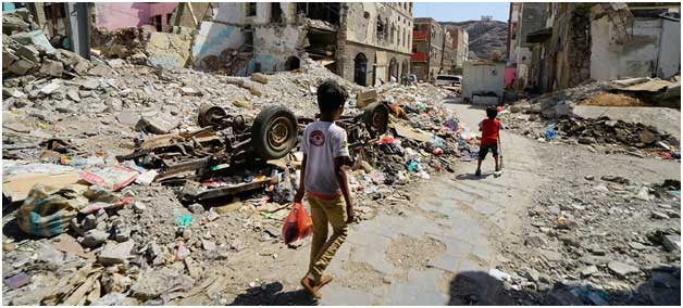 Dos niños transitan por una parte destruida del centro de Crater, un área de Adén, en Yemen. El área resultó gravemente dañada por los ataques aéreos en 2015, cuando las fuerzas de la coalición expulsaron a los insurgentes de la ciudad. Crédito: Giles Clarke/ONU