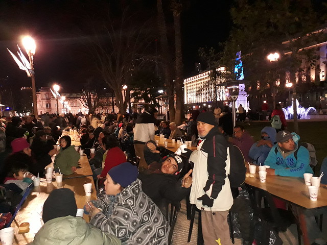 Durante una noche de frío polar en Argentina, personas necesitadas cenan caliente en la Plaza de Mayo, el principal espacio público de Buenos Aires, con la Casa Rosada, sede del gobierno, de telón de fondo. También reciben ropa de abrigo donada. Crédito: Daniel Gutman/IPS