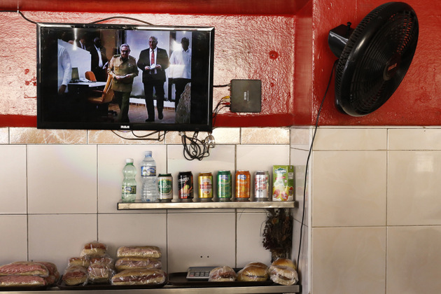 La pantalla de un televisor en una cafetería de La Habana, muestra aRaúl Castro, primer secretario del Partido Comunista de Cuba, y el prsidente Miguel Diaz–Canel, cuando se disponen a votar durante la sesión extraordinaria de La Asamblea Nacional del Poder Popular, el parlamento local. Crédito: Jorge Luis Baños/IPS