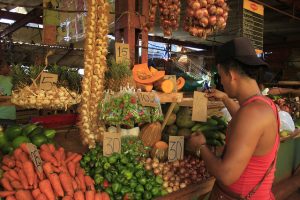 Un empleado coloca cartones con los precios sobre algunas hortalizas en un agromercado de gestión privada en Playa, uno de los 15 municipios que conforman la capital de Cuba. Crédito: Jorge Luis Baños/IPS