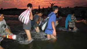 Migrantes centroamericanos atraviesan en medio de la noche uno de los ríos que deben sortear para alcanzar su meta de llegar a Estados Unidos, en un azaroso recorrido de miles de kilómetros. Crédito: Cortesía de Fonamih