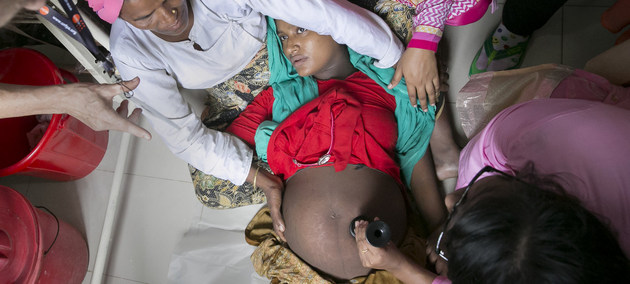 Sanitarios ayudan a una mujer embarazada en el centro de maternidad del campo de refugiados de Nayapara, en Bangladesh. Crédito: Allison Joyce/UNFPA