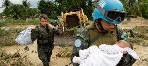 Un miembro brasileño de las fuerzas de mantenimiento de la paz de las Naciones Unidas rescata a un niño después de que partes de la capital de Haití, Puerto Príncipe, se inundaran durante una tormenta tropical en 2007. Crédito: Marco Dormino/ONU