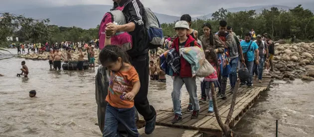 Migrantes venezolanos cruzan en 2019 el río Táchira, en la frontera suroeste de su país, para ingresar a Colombia. Venezuela, Siria, Afganistán, Sudán del Sur y Myanmar son los países con mayor número de sus nacionales desplazados a través de las fronteras en la última década. Foto: Vincent Tremeau/Acnur