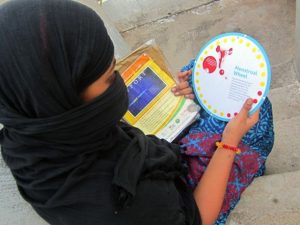 Una estudiante de secundaria en el este de India observa un folleto sobre higiene menstrual. Foto: Stella Paul/IPS