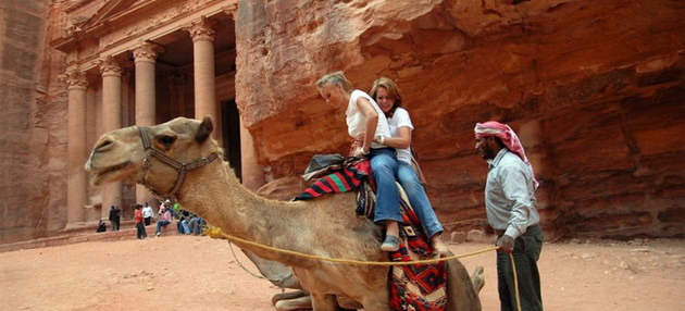 Turistas se disponen a dar un paseo en camello en Petra, en Jordania. La caída en la actividad turística significa un duro golpe para las economías de muchos países,con los del Sur en desarrollo entre los más afectados. Foto: OMT