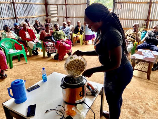 Una capacitadora muestra a integrantes de una pequeña comunidad rural de Kenia como se cocina en una olla eléctrica. Foto: Fiona Lambe/SEI