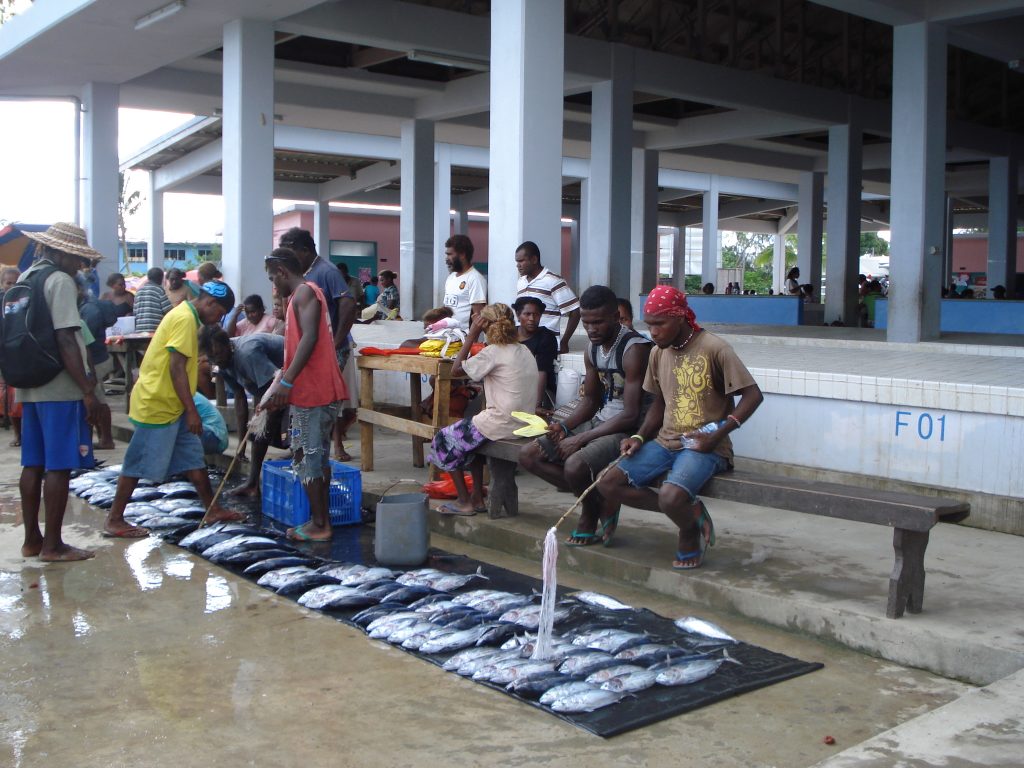 Hombres mostrando pescado en el piso como parte de la pesca de subsistencia.