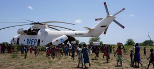 Suministros de emergencia son entregados a la población de una pequeña localidad de Sudán del Sur, tras llegar en un helicóptero del Programa Mundial de Alimentos (PMA). Foto: Peter Martell/Unicef