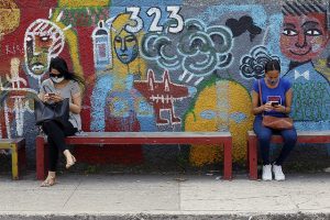 En Cuba, a medida que aumenta el acceso a internet crece también la violencia digital de género, como visibilizan campañas de información sobre el problema y las herramientas de las mujeres para defenderse. En la imagen dos mujeres residentes en La Habana interactúan con sus teléfonos móviles mientras esperan el ómnibus. Foto: Jorge Luis Baños/IPS