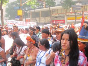 “Luchamos por la demarcación de nuestro territorio”, dice una pancarta en una marcha de indígenas de las que llegan hasta Río de Janeiro desde las comunidades de los 305 pueblos originarios de Brasil, para reclamar los derechos que les reconoce la Constitución y que el presidente ultradrechista Jair Bolsonaro comenzó a desconocer desde que comenzó su mandato. Foto: Mario Osava/IPS