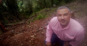 Héctor Velásquez, propietario de la finca cafetalera Los Robles, en una ladera del volcán de San Salvador, muestra un deslizamiento de tierra en su cafetal tras el paso de la tormenta tropical Amanda, en mayo. Con el apoyo del Programa de las Naciones Unidas para el Medio Ambiente, ha innovado sus medidas de prevención, como la introducción de barreras vivas y muertas. Foto: Edgardo Ayala/IPS