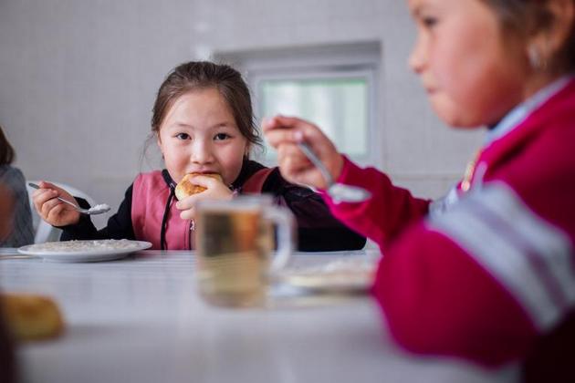 Nurel, de siete años, come un almuerzo saludable preparado por un cocinero en su escuela de Chon Kenin, Kirguistán. Millones de niños han perdido el último año el beneficio de la alimentación escolar. Foto: Zhanibekov/Unicef