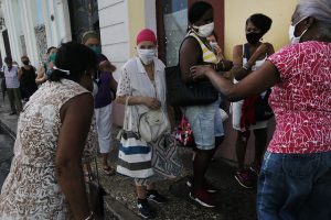 Adultos mayores, todos con mascarillas protectoras, aguardan en el exterior de una farmacia para la compra de medicamentos en medio de las restricciones impuestas para contener la expansión de la covid-19, en el municipio de Centro Habana, en la capital cubana. Iniciativas de acompañamiento a distancia buscan aportar apoyo psicosocial a segmentos de la envejecida población cubana. Foto: Jorge Luis Baños/IPS