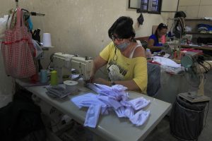 Mujeres confeccionan mascarillas para la protección ante la covid-19 en un taller de costura ubicado en el barrio del Vedado, en La Habana. Se trató de una de las primeras acciones solidarias efectuadas en Cuba ante la pandemia, acompañada de entrega de módulos con alimentos, medicinas y artículos de aseo a personas en condición de vulnerabilidad social. Foto: Jorge Luis Baños/IPS
