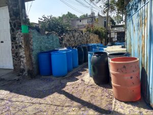 Los recipientes para almacenar el agua son parte del paisaje en las calles de Tehuixtitla. Los residentes de este barrio del sur de Ciudad de México los atesoran al lado de sus viviendas para complementar con ellos el suministro del recurso, mediante la compra de agua a los camiones cisterna, que guardan en bidones, algunos descoloridos por el sol y otros nuevos, para luego bombearla a sus viviendas. Foto: Emilio Godoy /IPS