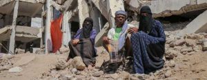 Una familia yemení junto a los escombros del edificio que antes fue su vivienda. Foto: OCHA