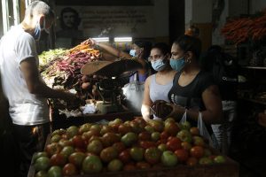 Clientes usan mascarillas protectoras contra el contagio de la covid, mientras adquieren alimentos en el interior de un estatal agromercado, en el municipio Centro Habana, en Cuba. Foto: Jorge Luis Baños/IPS