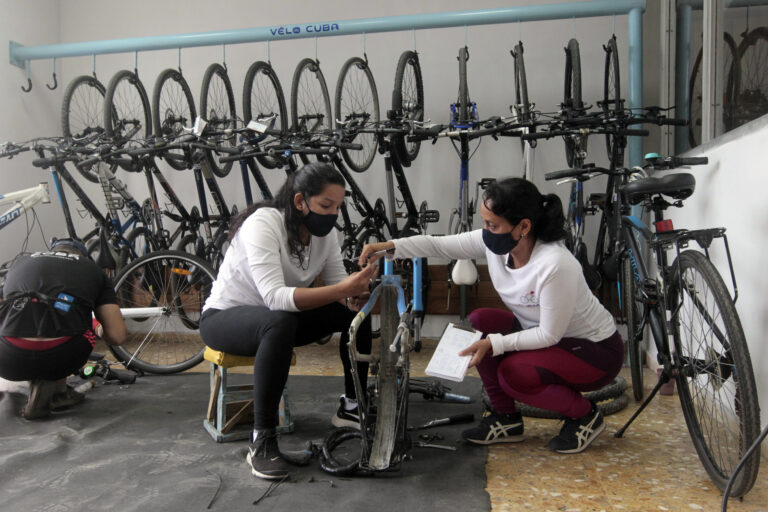 Nayvis Díaz (D), lideresa de la pequeña empresa Velocuba junto a una integrante del equipo de trabajo, Velocuba es una PYME dedicada a la reparación y alquiler de bicicletas, en La Habana, Cuba.04 de enero de 2022.Foto: Jorge Luis Baños/IPS
