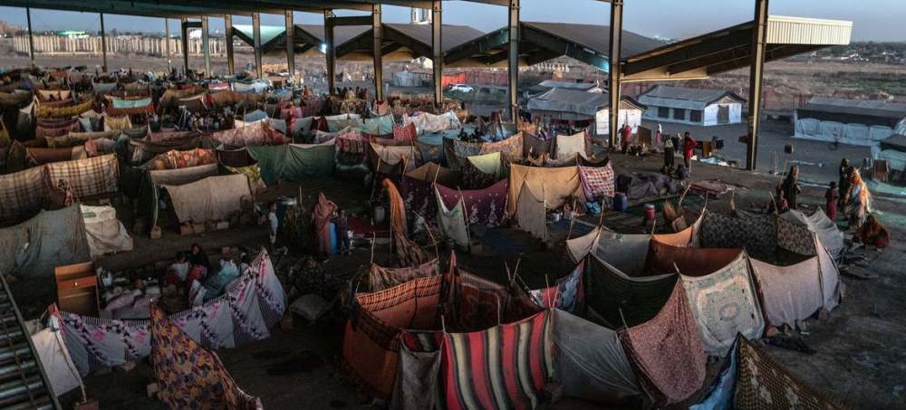 Una estación de autobuses en la ciudad de Gedaref, sureste de Sudán, sirve como campamento para miles de desplazados por la guerra en ese país africano. El conflicto, que dura 1000 días, ha generado la mayor crisis de hambre y desplazamiento en el mundo. Imagen: Giles Clarke / Unocha