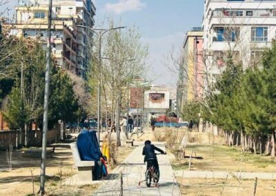 Dos mujeres sentadas en una banca en Kabul, mientras cuidan a un niño que juega en una bicicleta. Según las nuevas leyes de los talibanes, una esposa que visite a sus familiares sin el permiso de su marido se enfrenta a hasta tres meses de prisión. Imagen: Learning Together