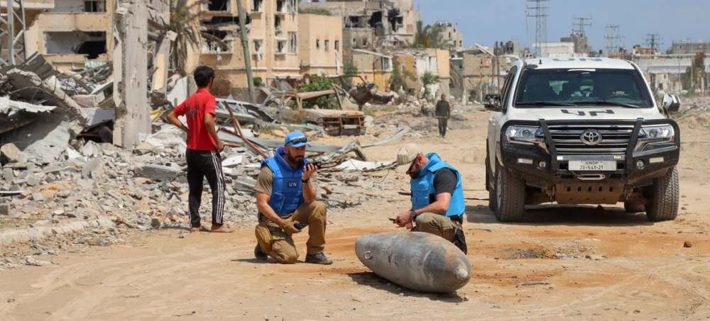 2025 marcó otro récord de violencia contra los trabajadores humanitarios, con 907 muertos, heridos o secuestrados mientras auxiliaban a la población civil en medio de conflictos y desastres - Un equipo de auxilio de la ONU inspecciona una bomba sin detonar en una vía de la Franja de Gaza. En ese territorio palestino y en otros escenarios de conflictos armados murieron más de 1000 trabajadores humanitarios en los últimos tres años mientras prestaban asistencia a la población civil. Imagen: Themba Linden / Unocha